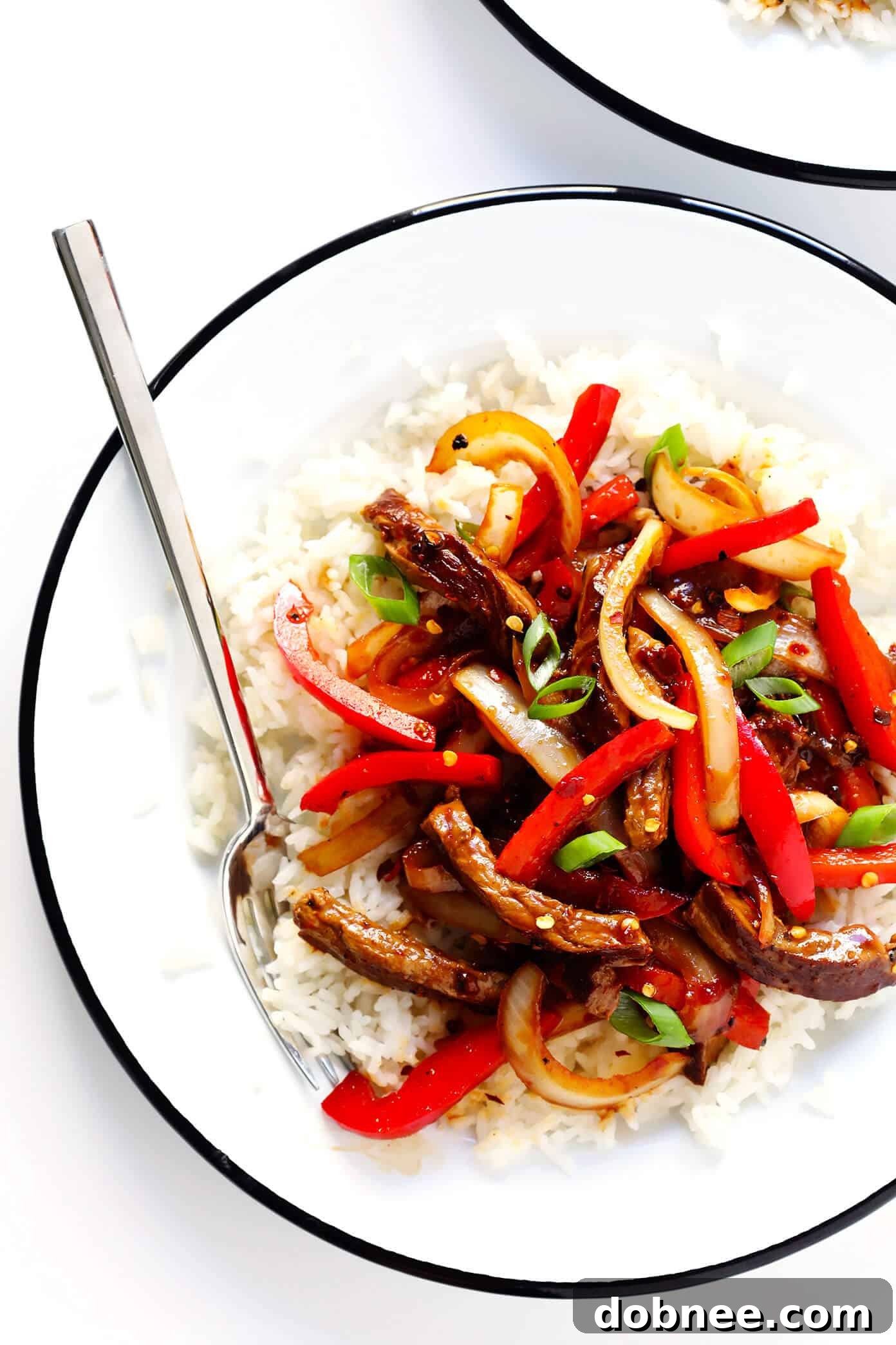 Delicious Szechuan Beef Stir-Fry served in a bowl, garnished with green onions.