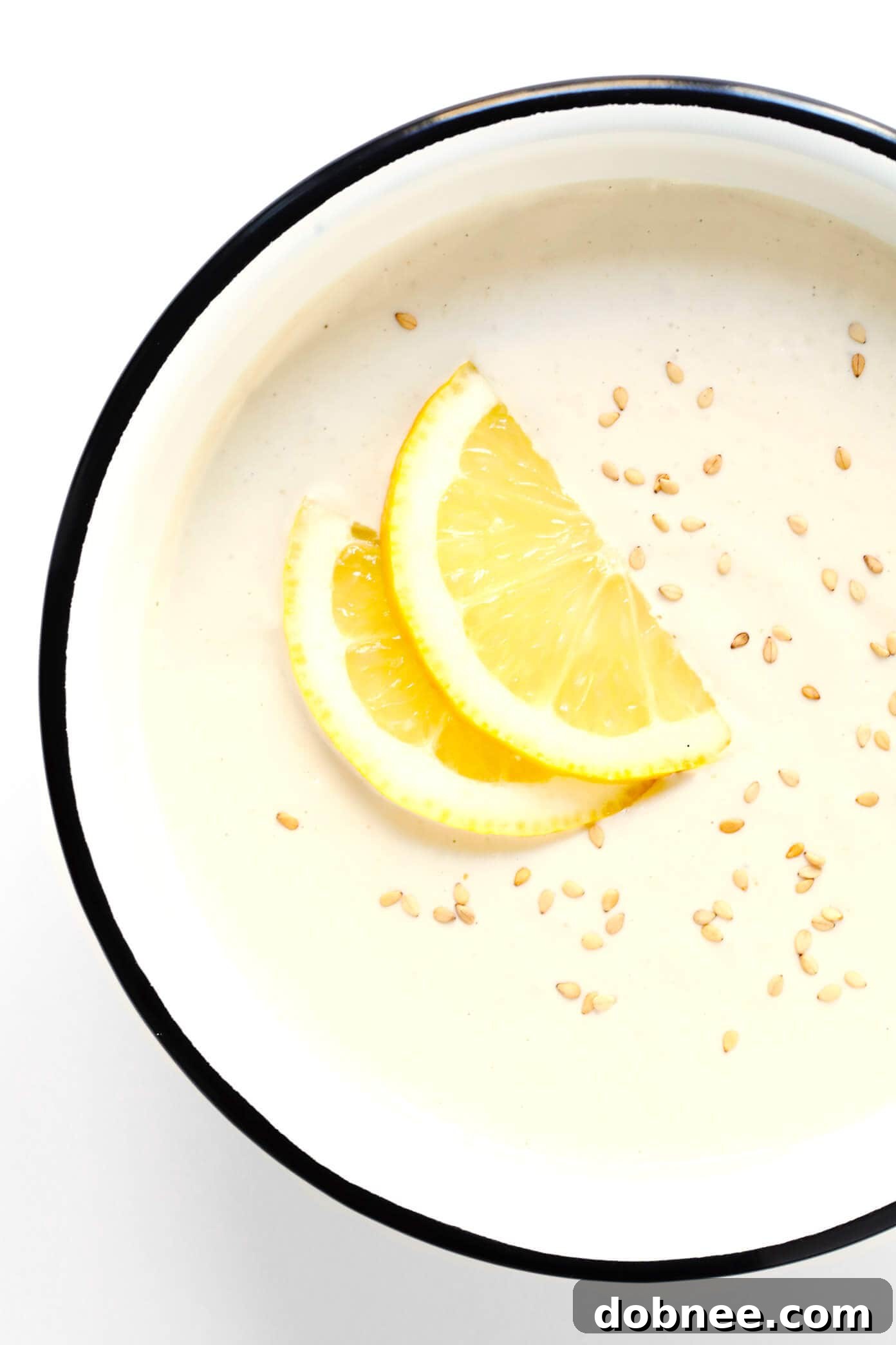 Perfectly Blended Tahini Dip: Simple & Elegant Smooth Tahini Dip in a bowl, garnished with sesame seeds and lemon zest.