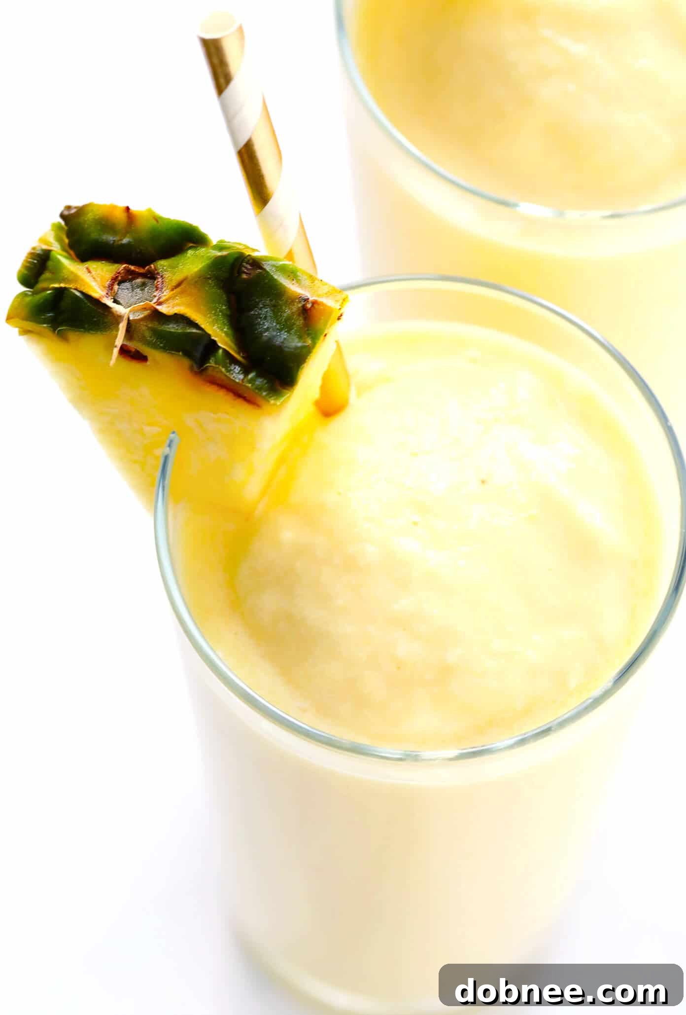 Easy Piña Colada Recipe - A close-up of a perfectly blended Piña Colada, garnished and ready to enjoy, highlighting its smooth texture and vibrant color.