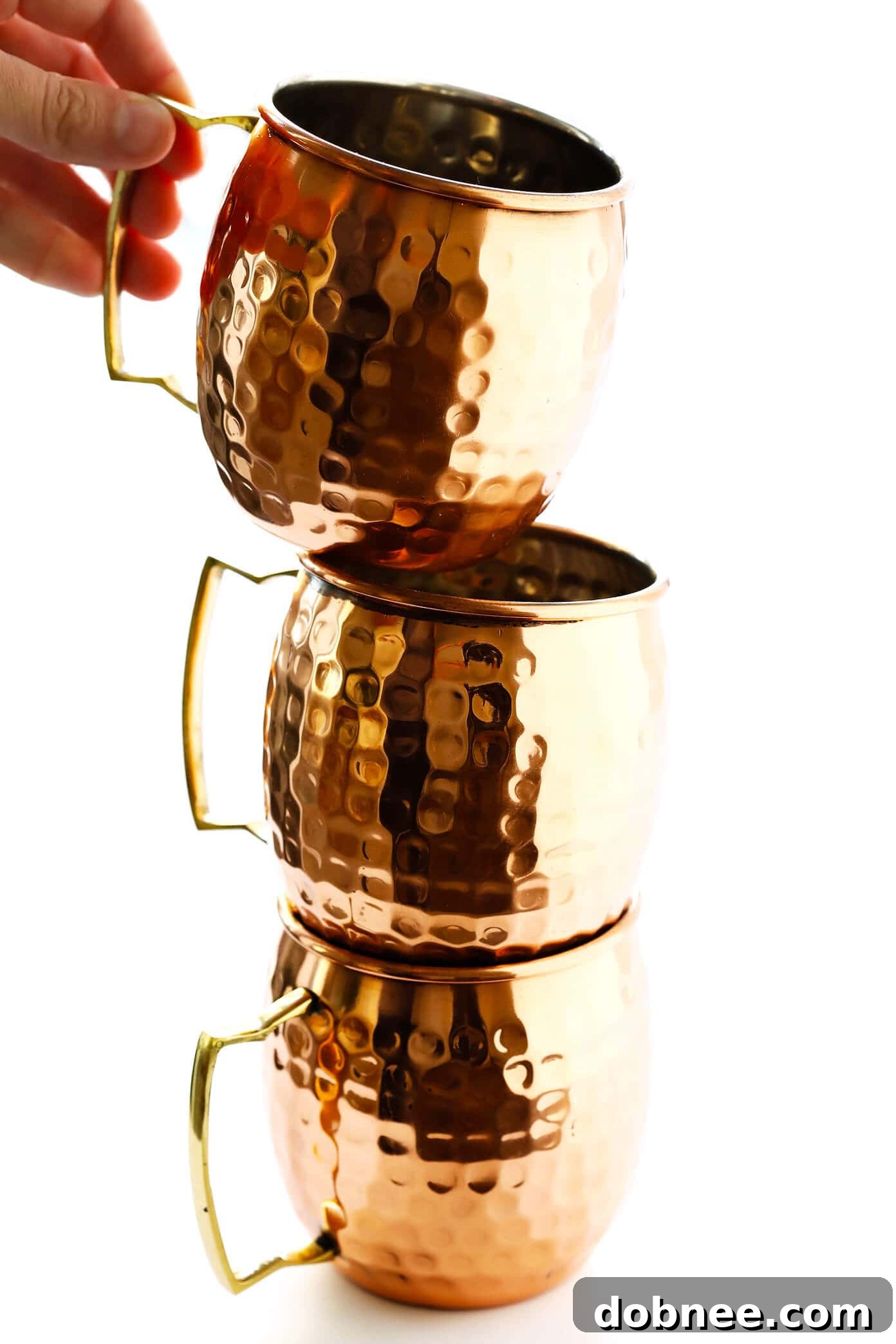 A collection of gleaming copper Moscow Mule mugs, perfect for serving this refreshing cocktail.