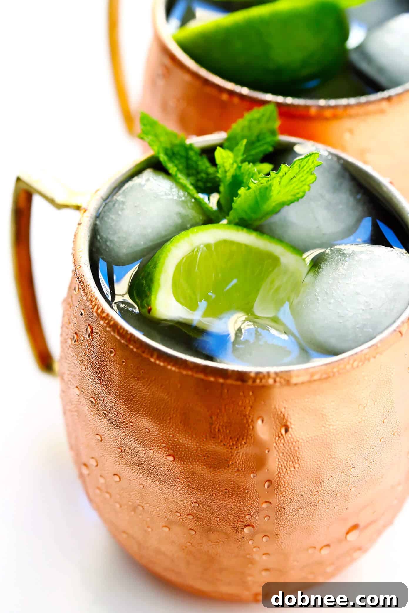 A trio of vibrant Moscow Mules in copper mugs, showcasing different garnishes and variations.