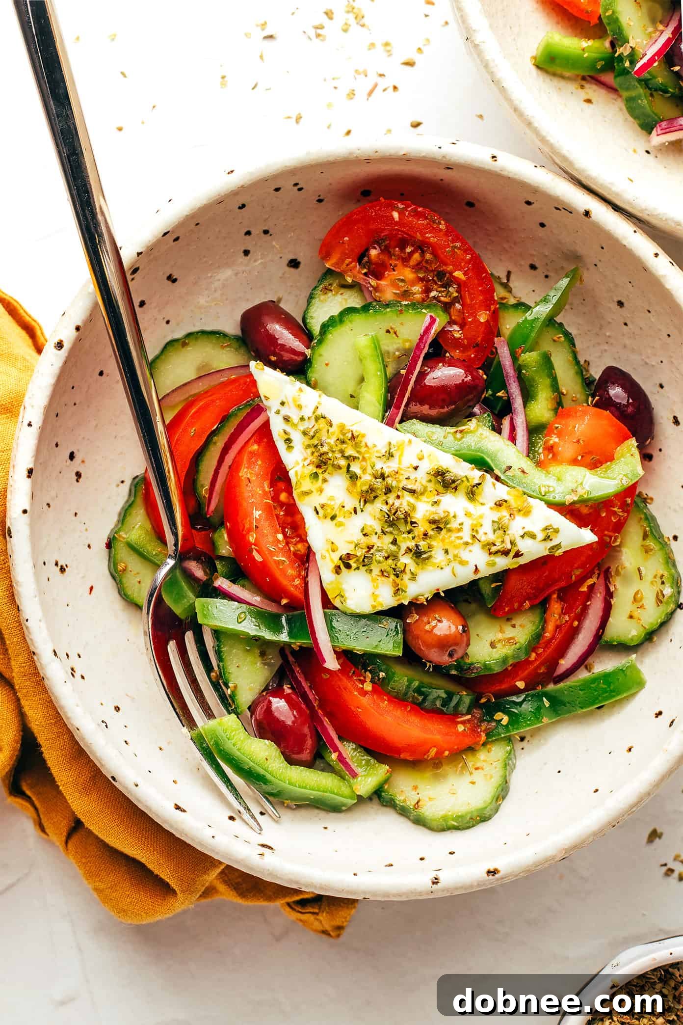 An inviting spread featuring Greek Salad, pita bread, and dips