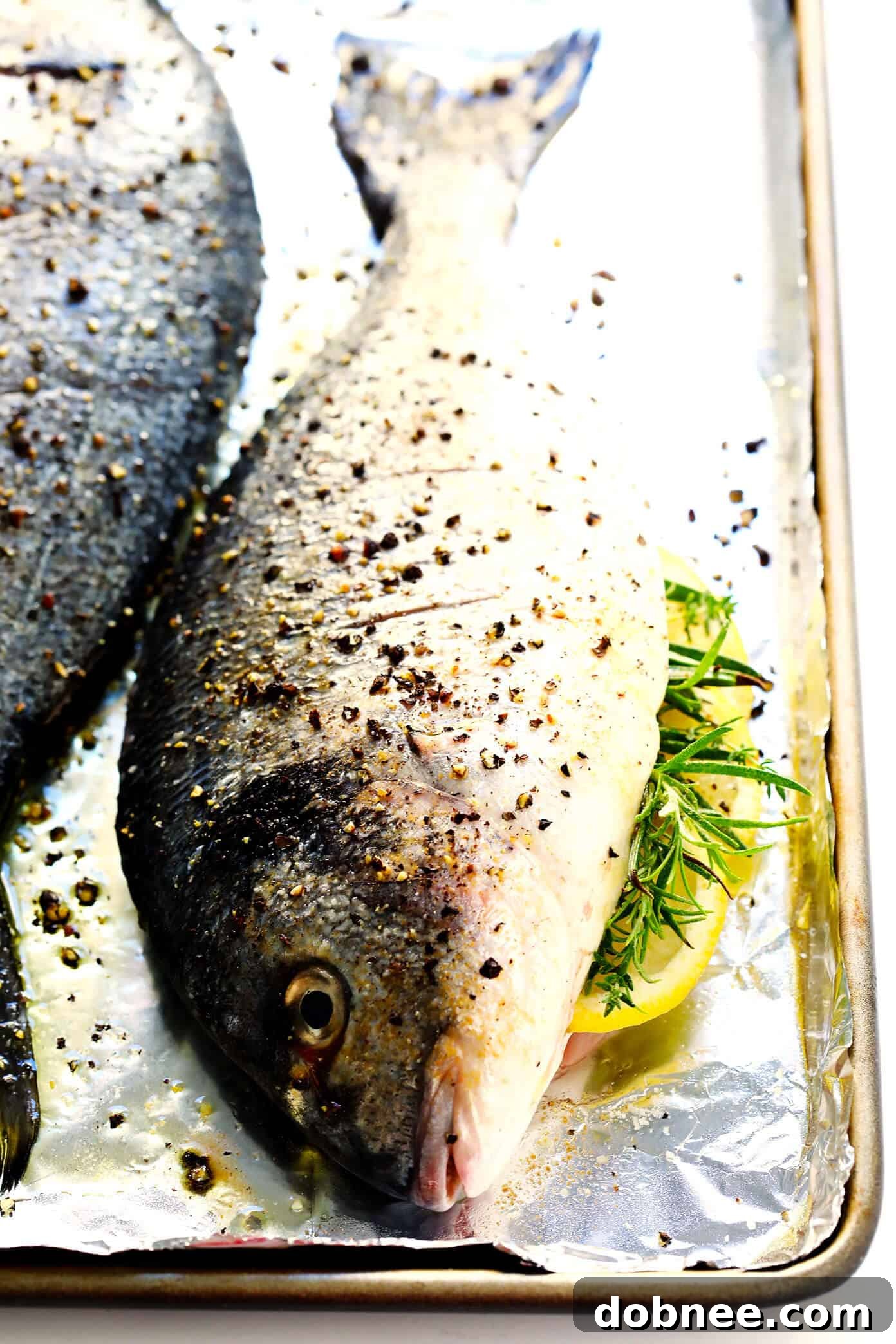 A straightforward guide on how to perfectly roast whole fish, ensuring a juicy interior and crispy skin every time. Seasoned with simple lemon, garlic, and herbs. How to Roast Fish in the Oven