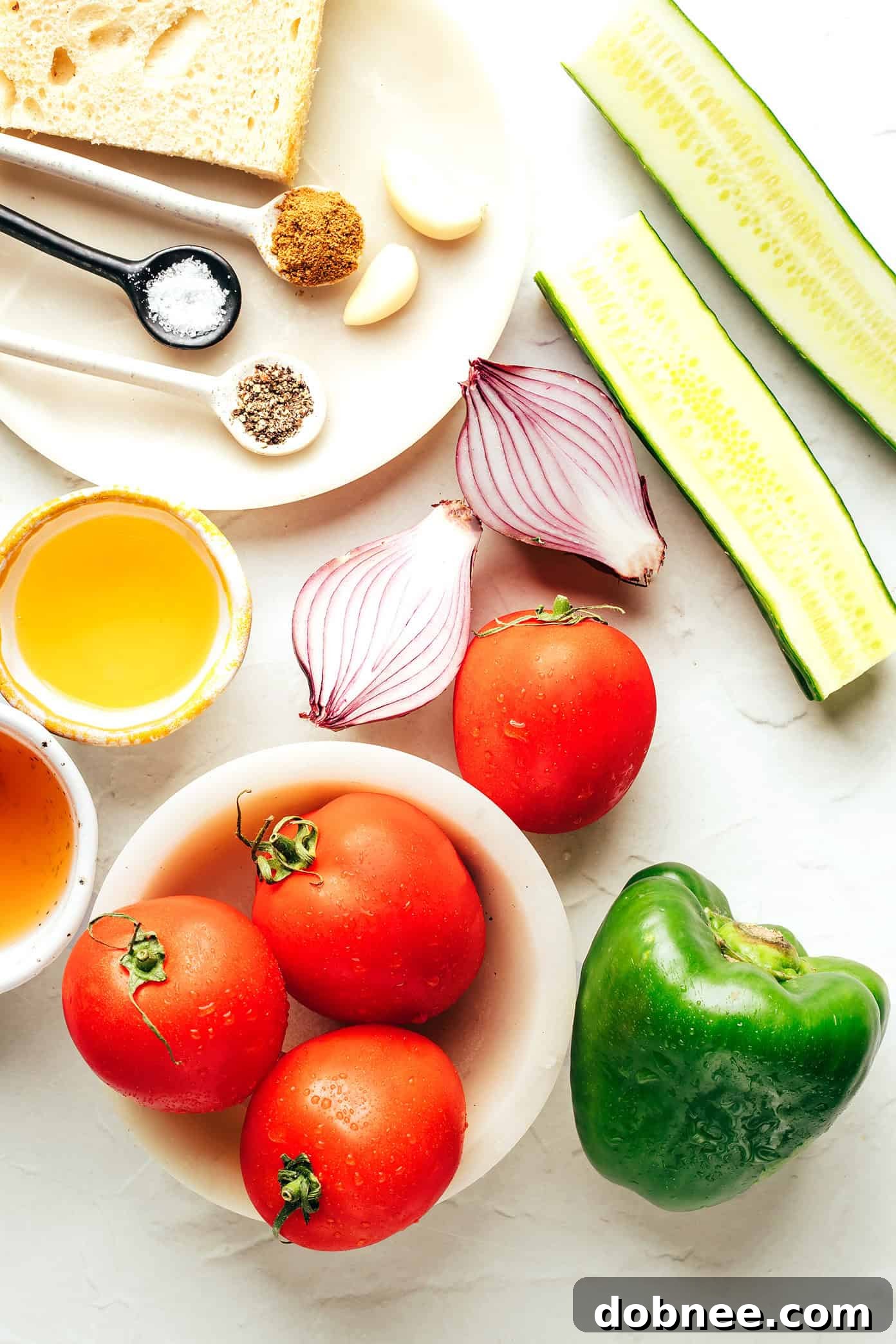 Close-up of fresh, ripe tomatoes, cucumber, and bell pepper, essential ingredients for gazpacho.