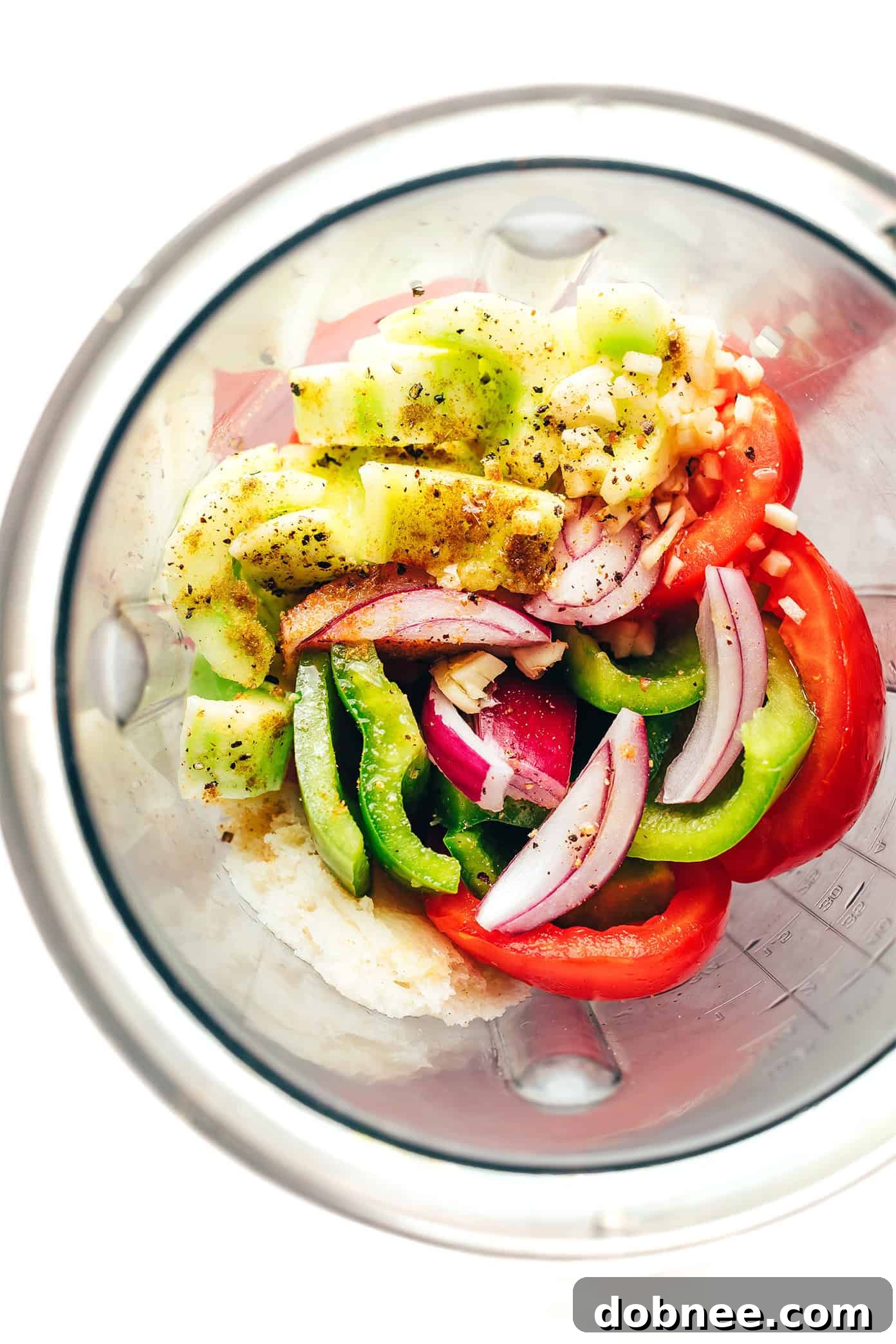 All the fresh ingredients for gazpacho laid out on a cutting board, ready for preparation.