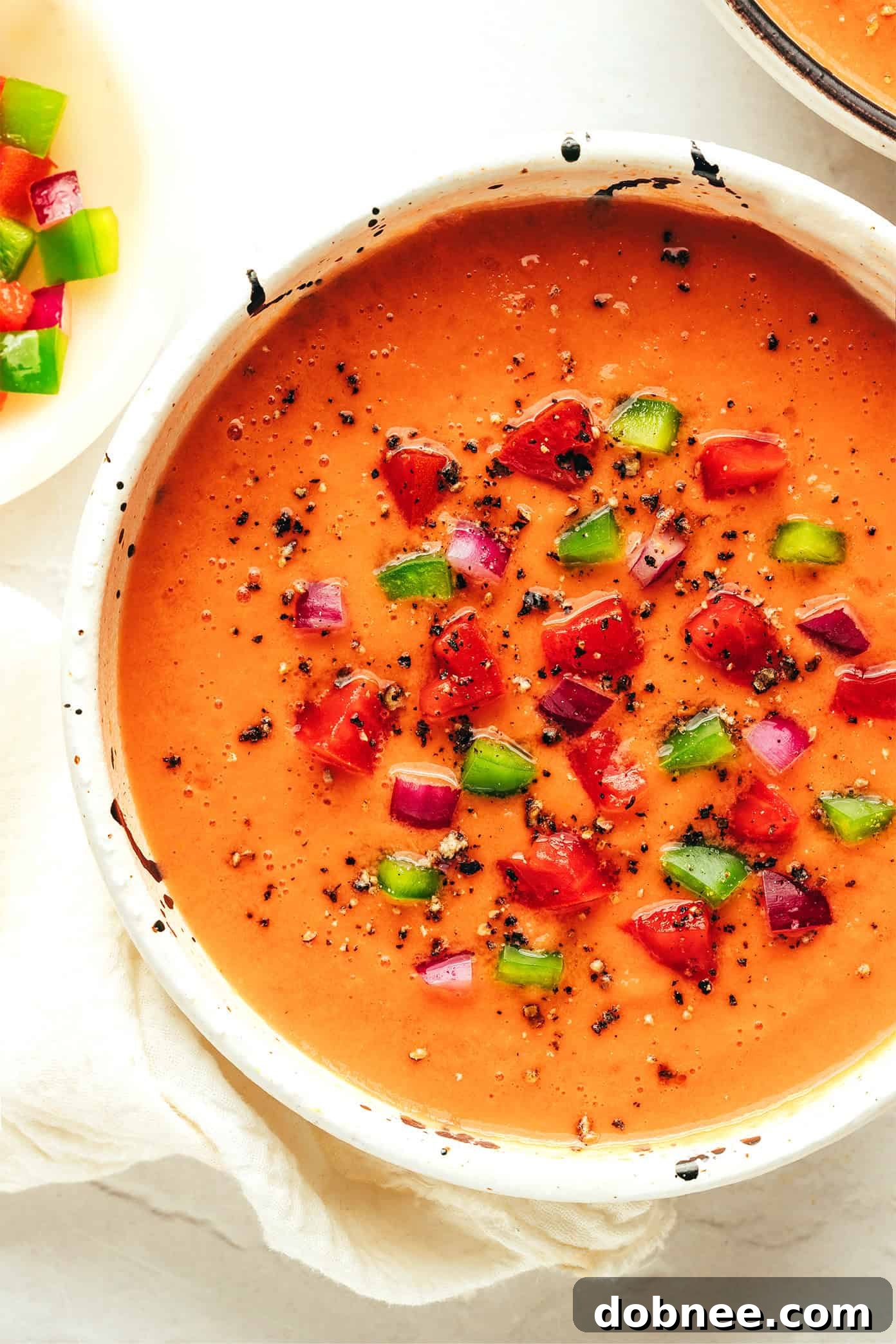 A perfectly blended, smooth gazpacho being poured into a serving glass.