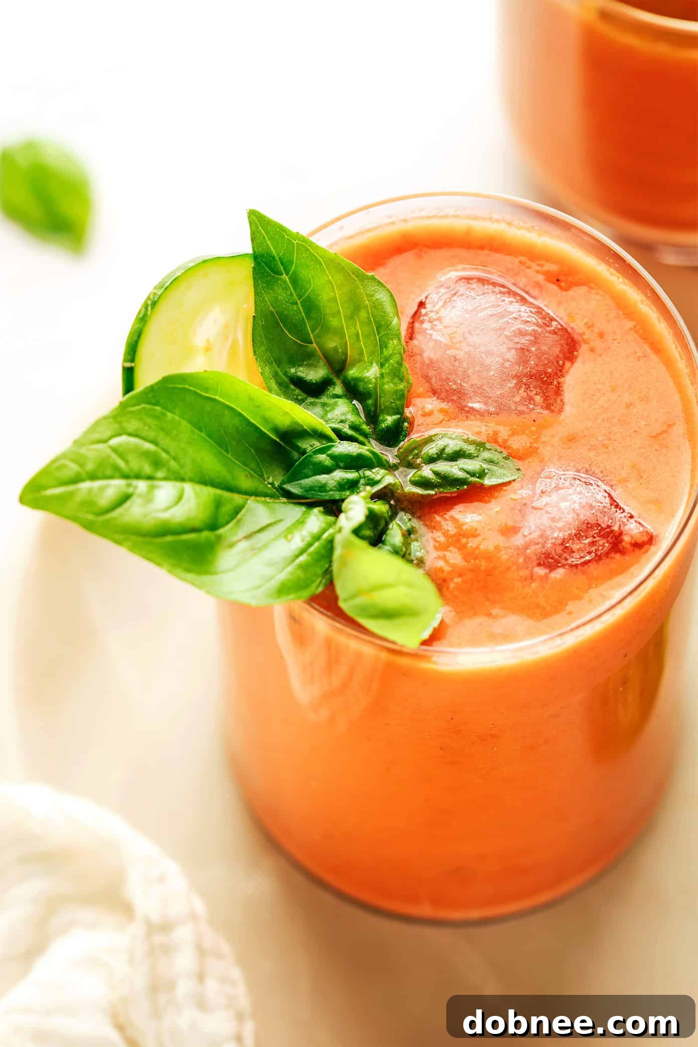 A beautifully presented bowl of gazpacho with various toppings like fresh herbs, croutons, and olive oil.