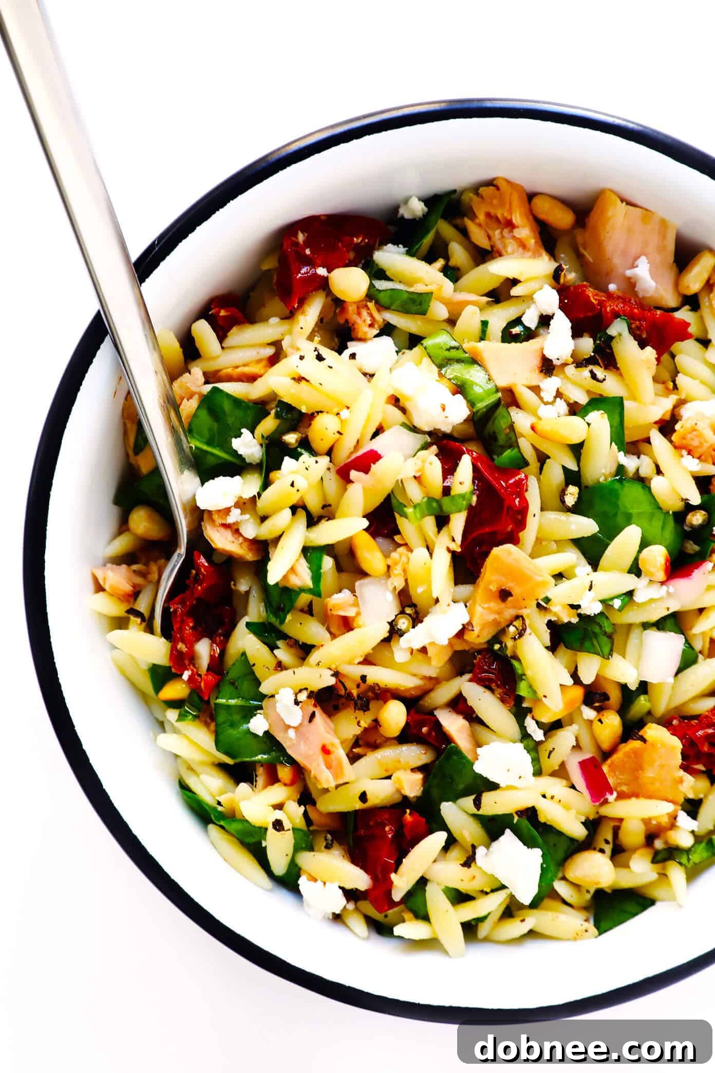 Delicious Italian Orzo Tuna Salad with chilled pasta, sun-dried tomatoes, pine nuts, feta cheese, and fresh basil in a lemon dressing. Perfect for make-ahead lunches or dinners.