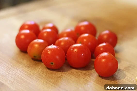 Appetizing close-up of sautéed shrimp with bright red tomatoes and green spinach, glistening with olive oil.