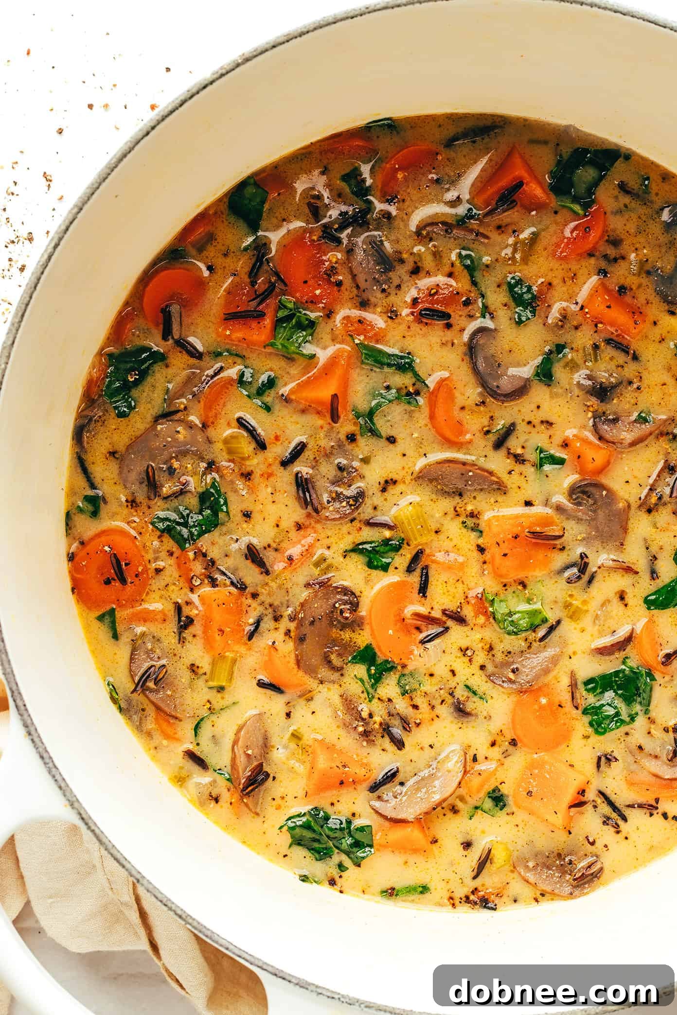 A large pot of creamy autumn wild rice soup simmering on the stovetop