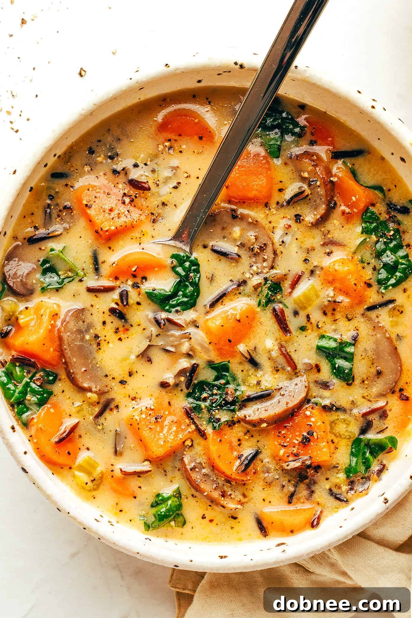 Another close-up of the finished autumn wild rice soup in a bowl, garnished