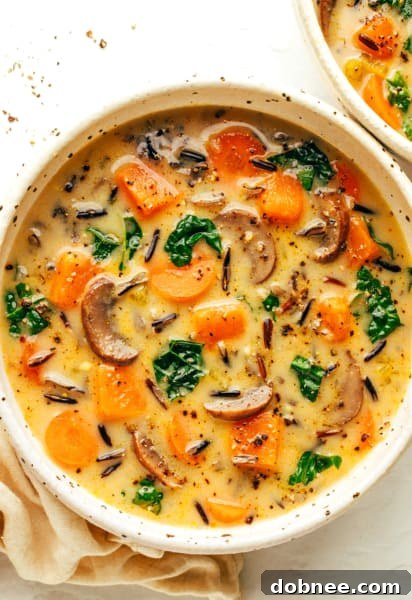 A bowl of Cozy Autumn Wild Rice Soup with a side of bread