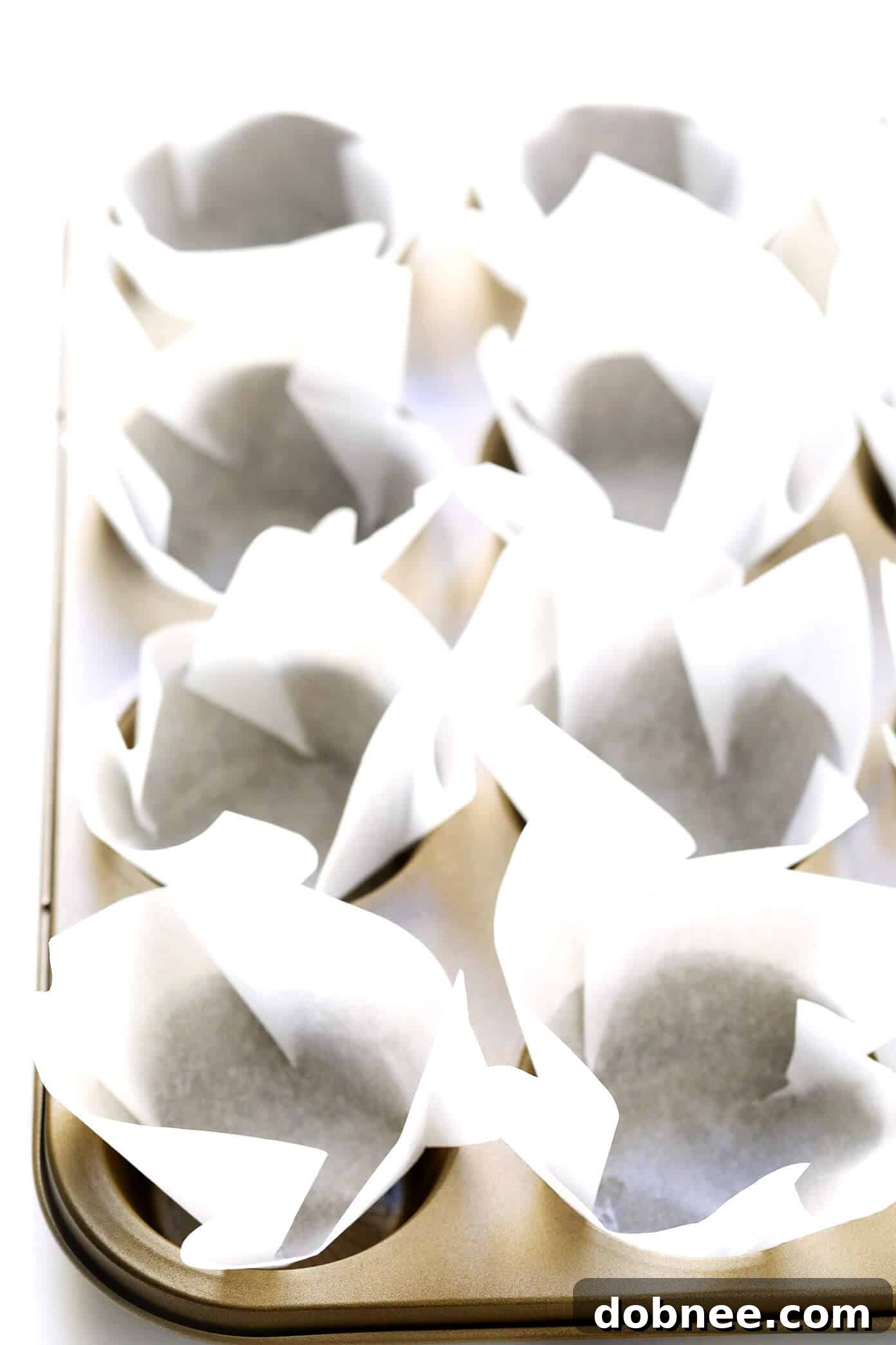 DIY Parchment Tulip Baking Cups: Close-up of perfectly formed homemade liners in a muffin tin.