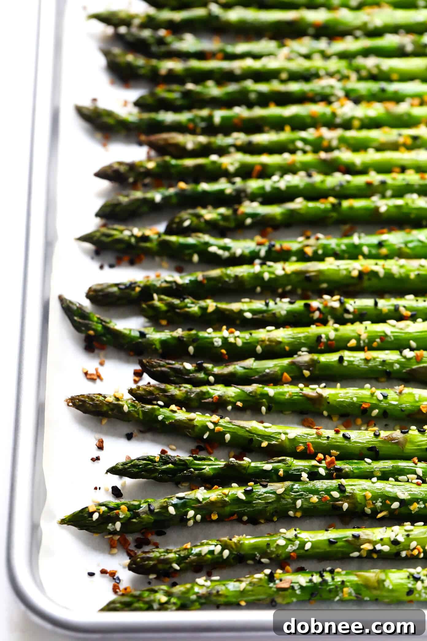 Kick your roasted asparagus recipe up a notch this season with some everything bagel seasoning! It's super quick and easy to make, naturally vegan and gluten-free, and makes the most delicious healthy side dish. Close-up of "Everything" Roasted Asparagus, showcasing the seasoning.