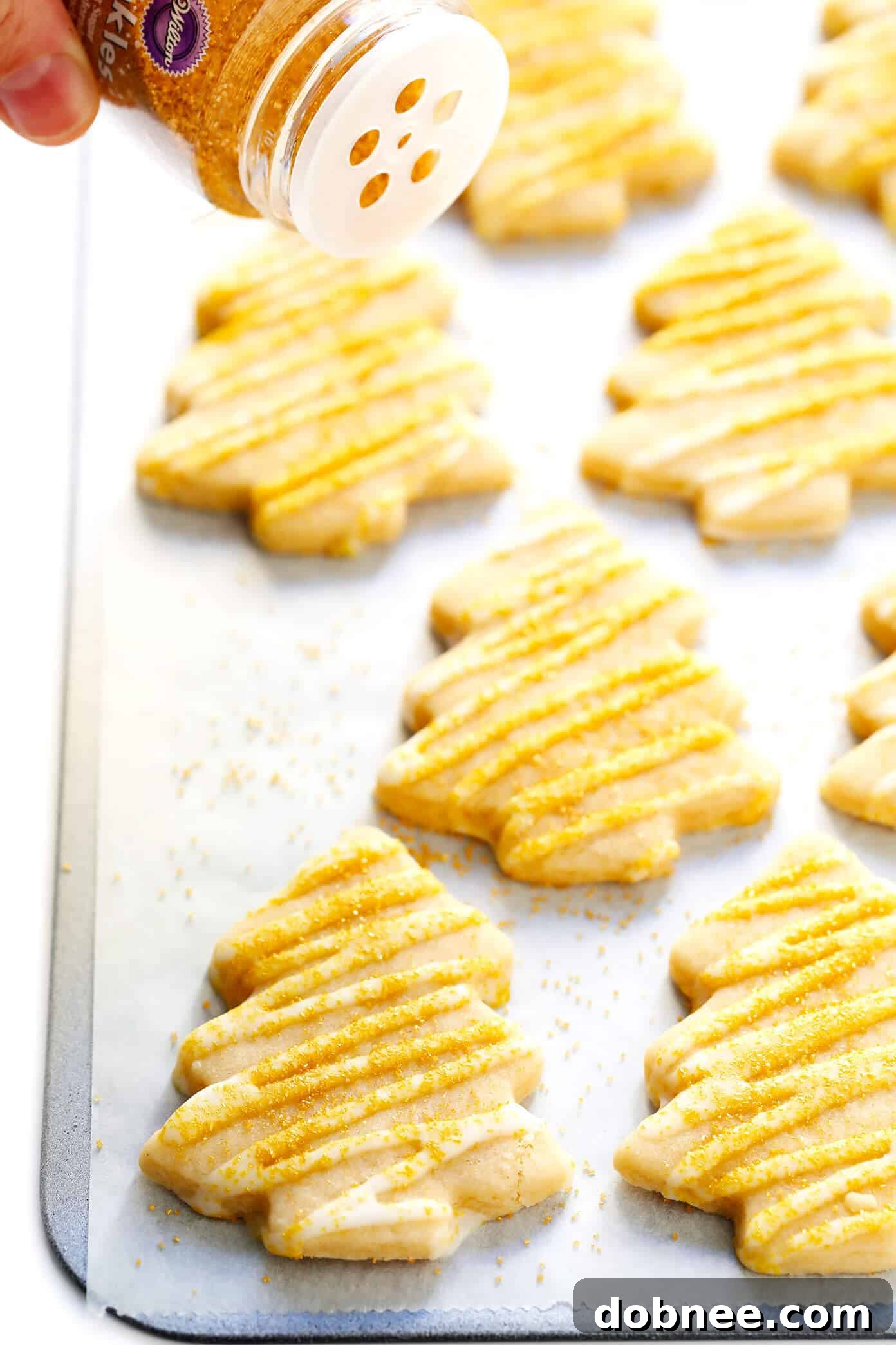 Brown Sugar Christmas tree cookies adorned with elegant gold sprinkles, perfect for festive celebrations.