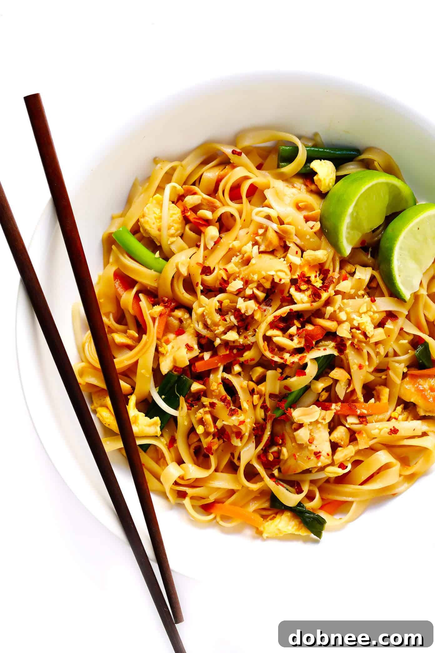 Close-up of freshly cooked Chicken Pad Thai with lime and peanuts