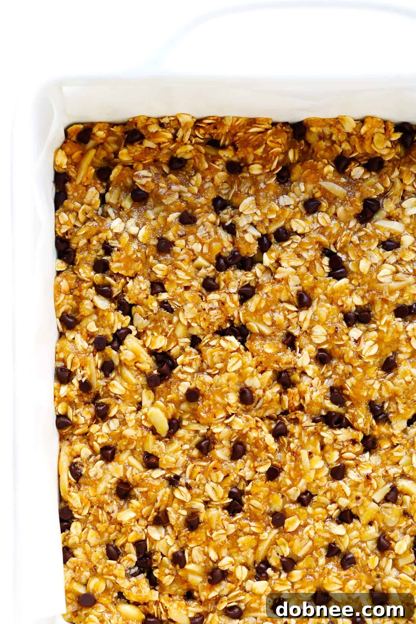 A perfectly cut healthy granola bar showing layers of oats, peanut butter, and chocolate chips.