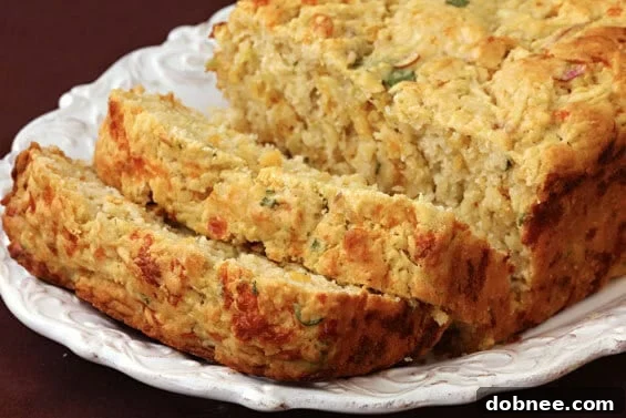 Freshly baked Apple Cheddar Bread, sliced to reveal moist interior with flecks of apple and cheddar cheese.