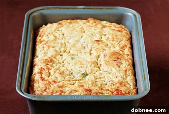 Close-up of a warm slice of Apple Cheddar Bread, showing the fluffy texture, melted cheddar, and tender apple pieces.