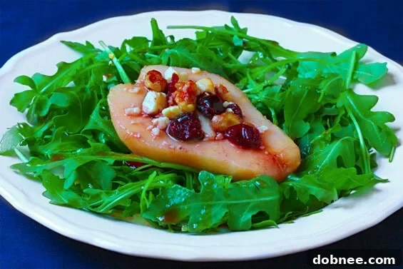 Close-up of a vibrant Roasted Pear, Blue Cheese & Arugula Salad on a white plate
