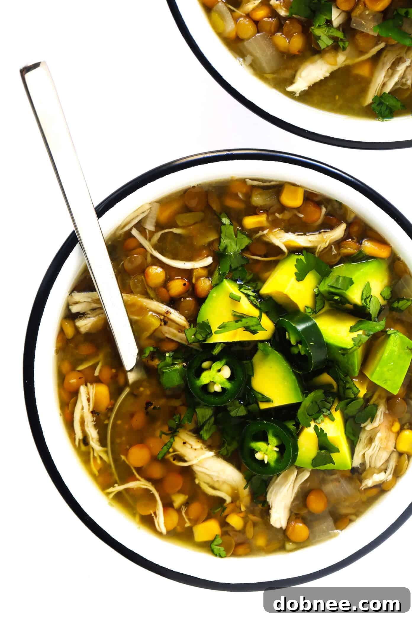 Mexican Chicken Lentil Soup topped with a generous amount of fresh avocado and cilantro.