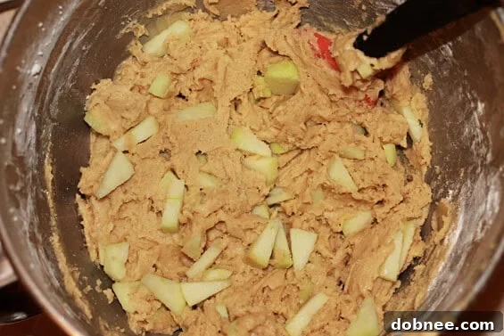 A close-up of freshly baked Appledoodles, showcasing their golden-brown edges and soft, chewy centers with visible apple pieces and cinnamon sugar topping.
