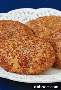 Stack of warm Appledoodles on a cooling rack, dusted with cinnamon sugar, ready to be enjoyed.