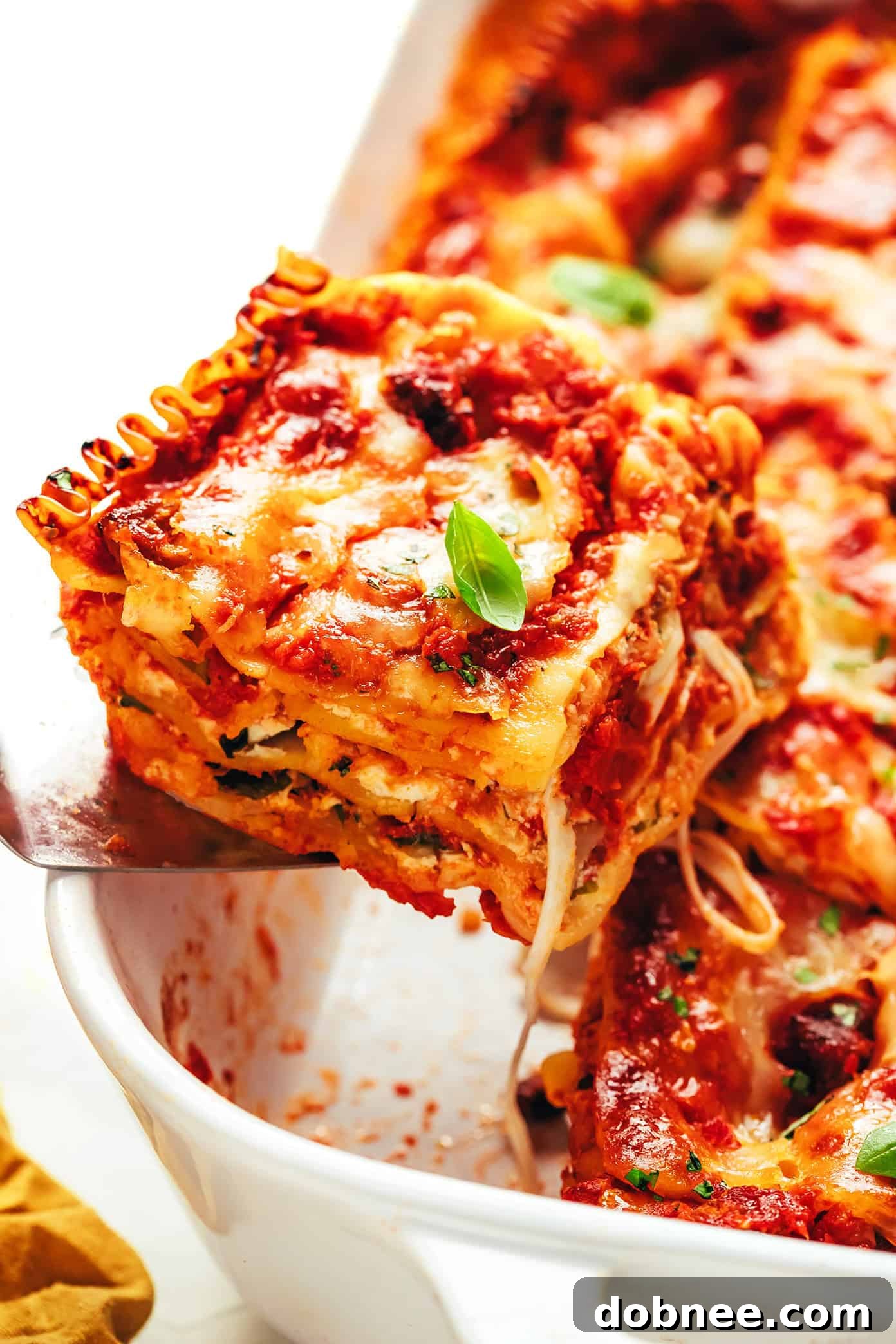 Two hands holding a pan of lasagna, symbolizing homemade comfort food and sharing.
