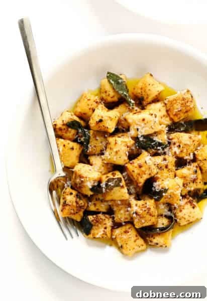 Homemade Ricotta Gnocchi with Lemony Sage Brown Butter Sauce in a pan, garnished with fresh sage and Parmesan.