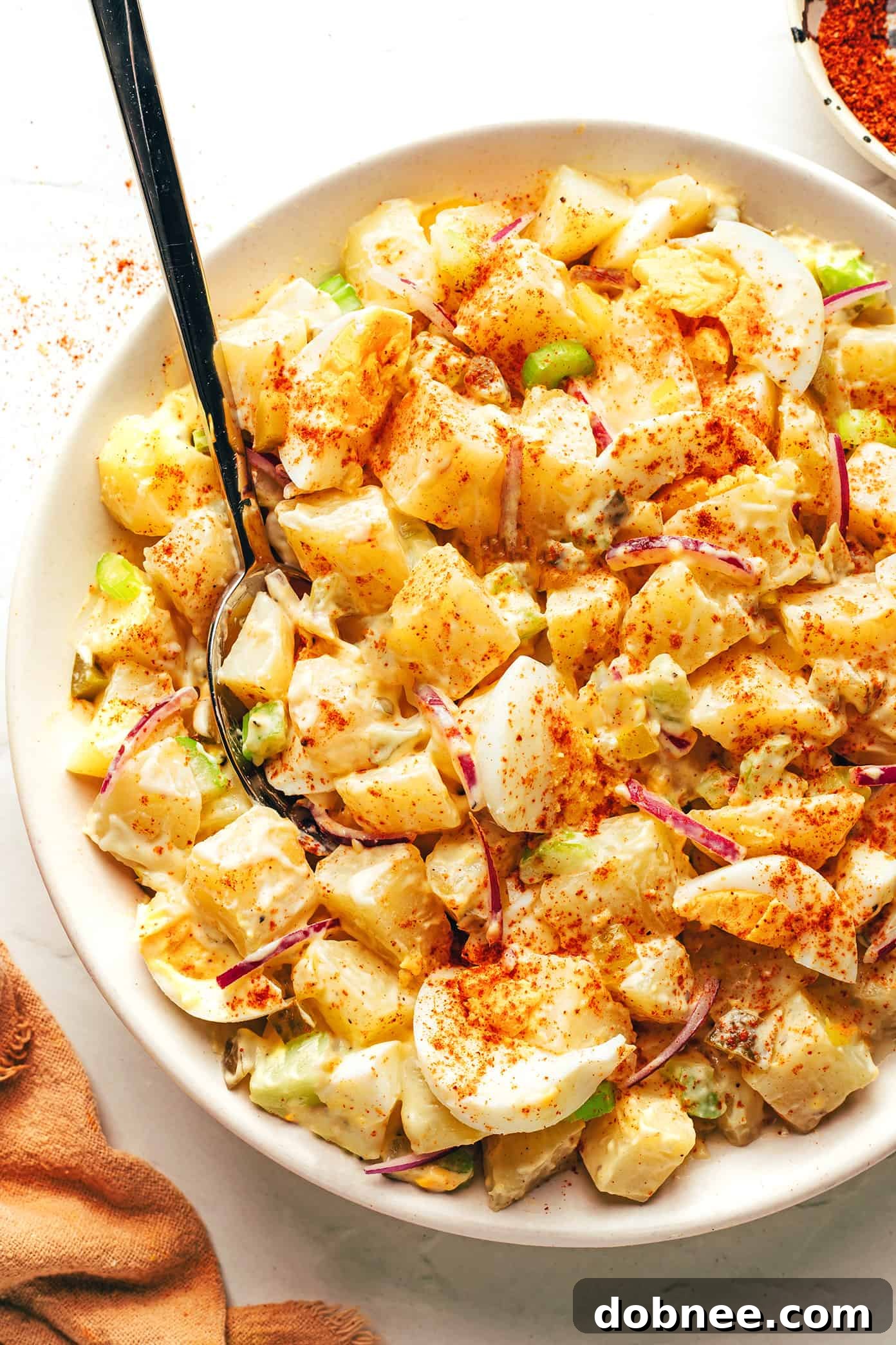 Classic potato salad in a bowl with spoon