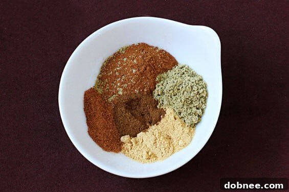 Close-up of a stack of Vanilla Chai Cupcakes, showcasing the soft texture and generous swirl of cinnamon buttercream, perfect for a special occasion.