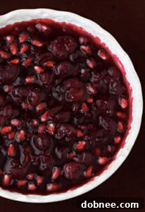 A bowl of freshly made Cranberry-Pomegranate Sauce ready to be served, bright red and inviting.