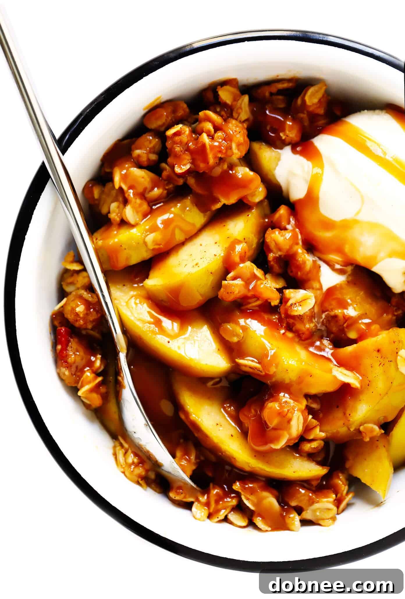 A side view of an apple crisp, showing layers of fruit and oatmeal topping.