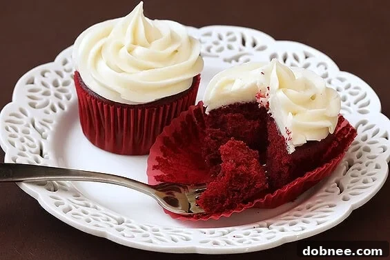 Freshly baked Red Velvet Cupcakes cooling on a wire rack, ready for their delicious cream cheese frosting.