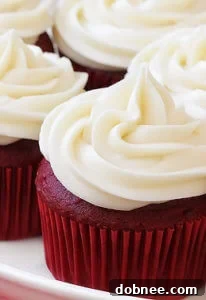 A stack of three beautifully frosted Red Velvet Cupcakes.