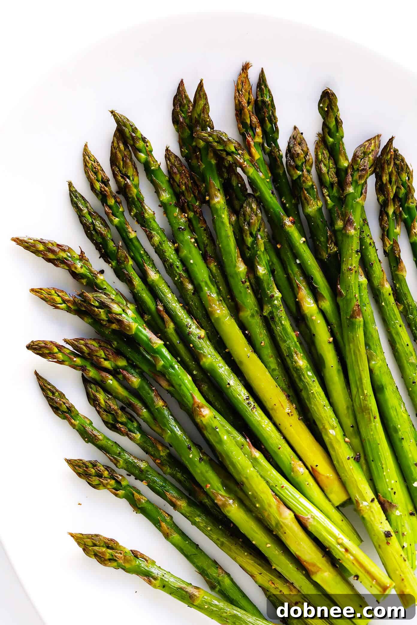 A selection of various roasted vegetables including asparagus, broccoli, and Brussels sprouts on different baking sheets, emphasizing healthy and diverse vegetable roasting options.