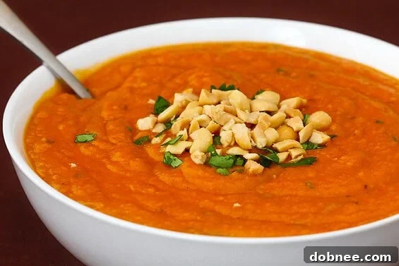 A steaming bowl of West African Peanut Soup, garnished with fresh cilantro and crushed peanuts.