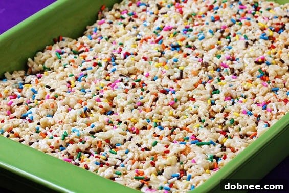 Close-up of vibrant cake batter rice crispy treats with colorful sprinkles.