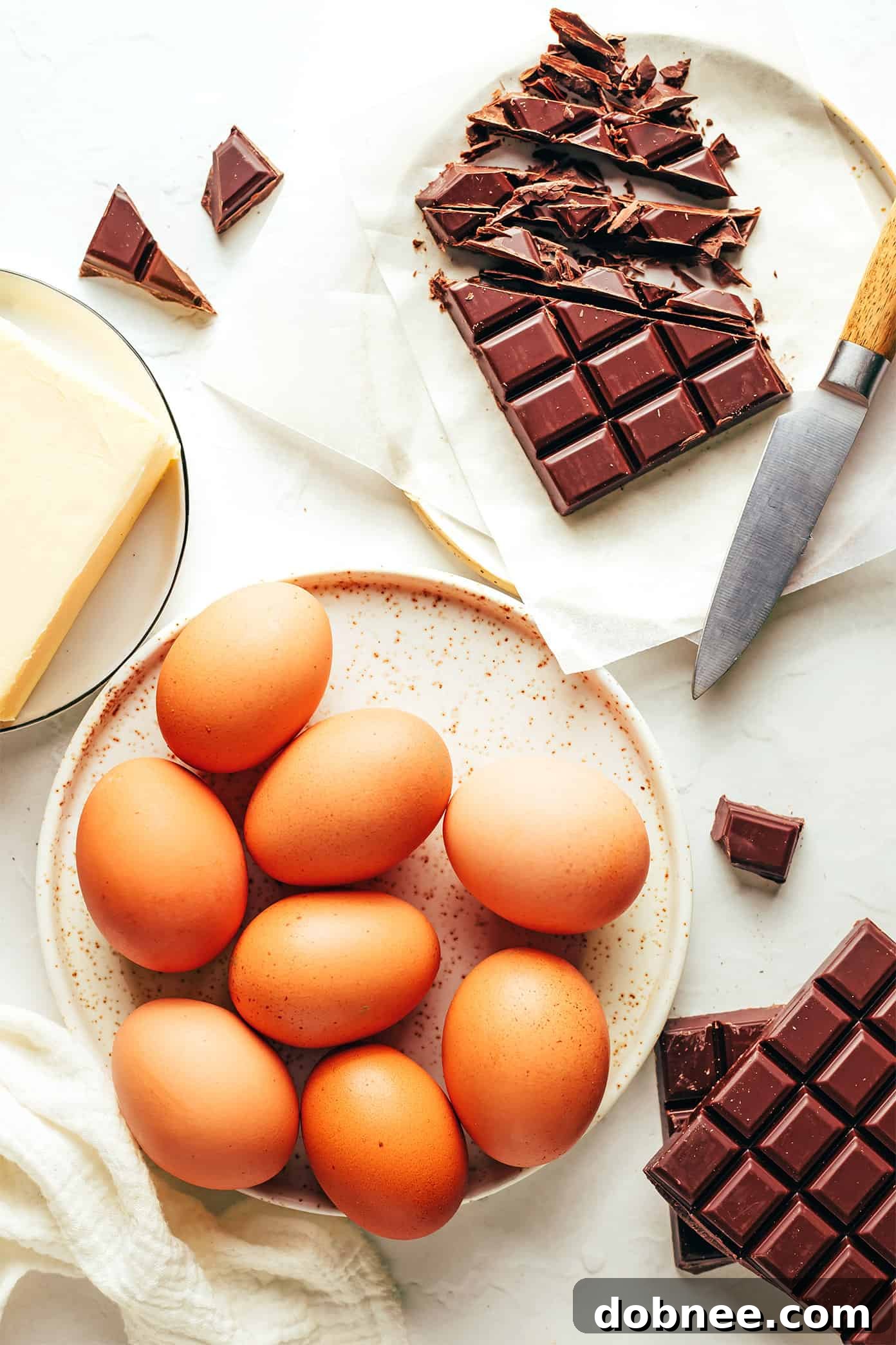 Flourless Chocolate Cake ingredients laid out on a table: chocolate, eggs, and butter.
