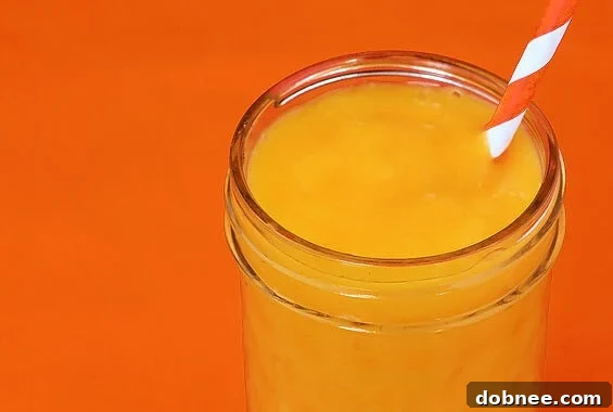 Vibrant Orange Smoothie with a hint of fresh ginger, garnished with orange slices and mint leaves