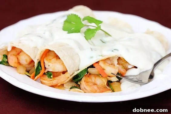 Verde Shrimp Enchiladas With Jalapeno Cream Sauce | Your ultimate recipe guide Delicious Verde Shrimp Enchiladas with Jalapeno Cream Sauce, garnished with fresh cilantro.