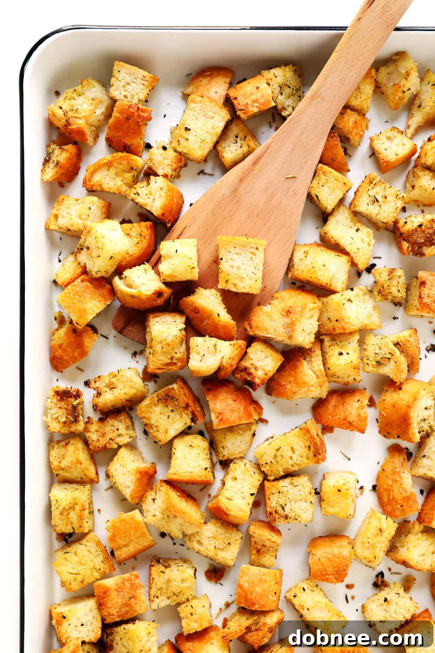 The BEST Homemade Croutons Recipe - A close-up of golden brown, crispy croutons scattered on a baking sheet, ready to be enjoyed.