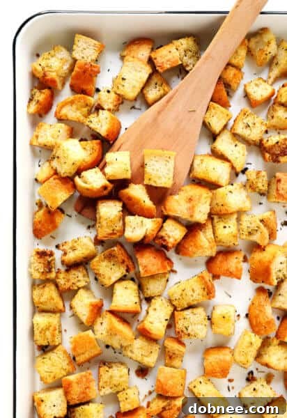 Homemade Croutons Recipe - A small, appetizing photo of golden croutons in a bowl with a hint of green, suggesting their use in salads.