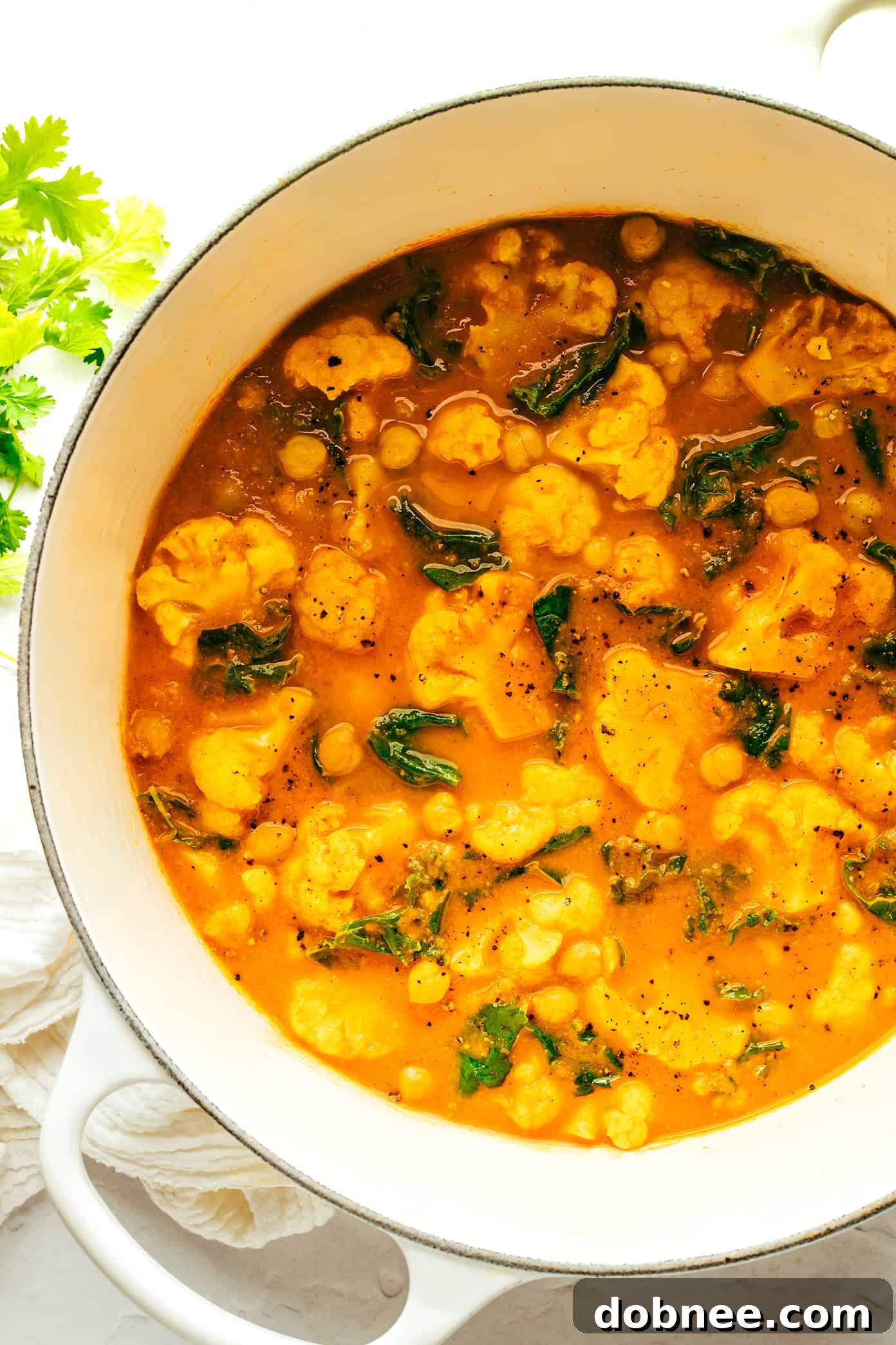 Heartwarming Cauliflower Curry 5 A close-up of a serving of cauliflower curry with rice and fresh cilantro.