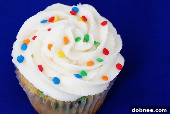 Close-up of a perfectly baked Funfetti cupcake on a cooling rack, showcasing its colorful sprinkles within the cake base.