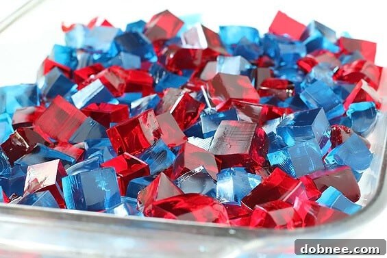 Close-up of Stained Glass Jello cubes in a large serving pan, showing the clear individual gelatin blocks and creamy white layers.