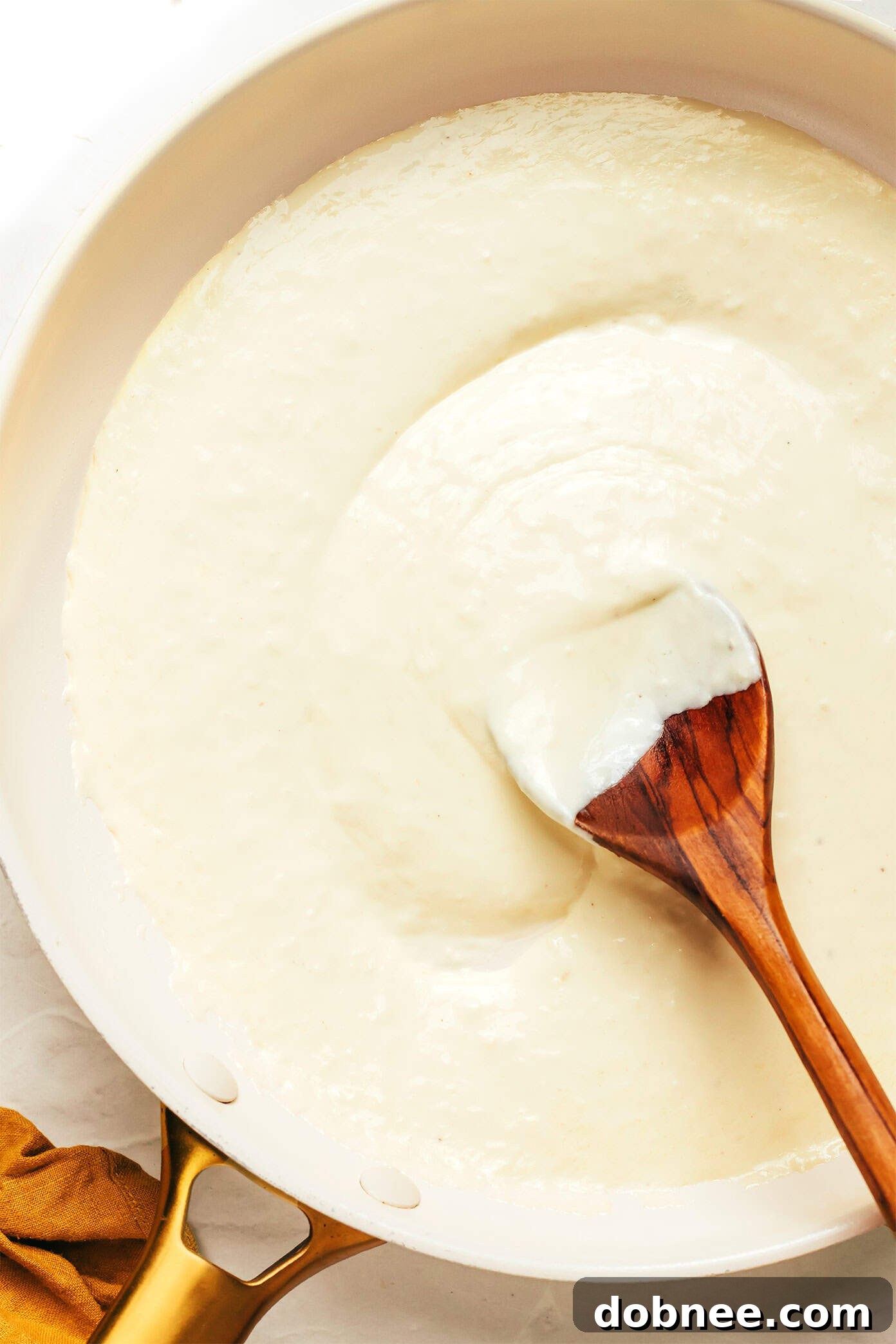 A bowl of freshly made Alfredo sauce, garnished with parsley and ready to be served.