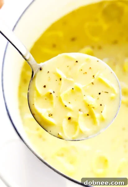A bowl of creamy Lemony Artichoke Soup with fresh lemon and herbs.