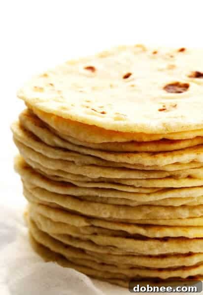 A stack of perfectly cooked homemade flour tortillas.