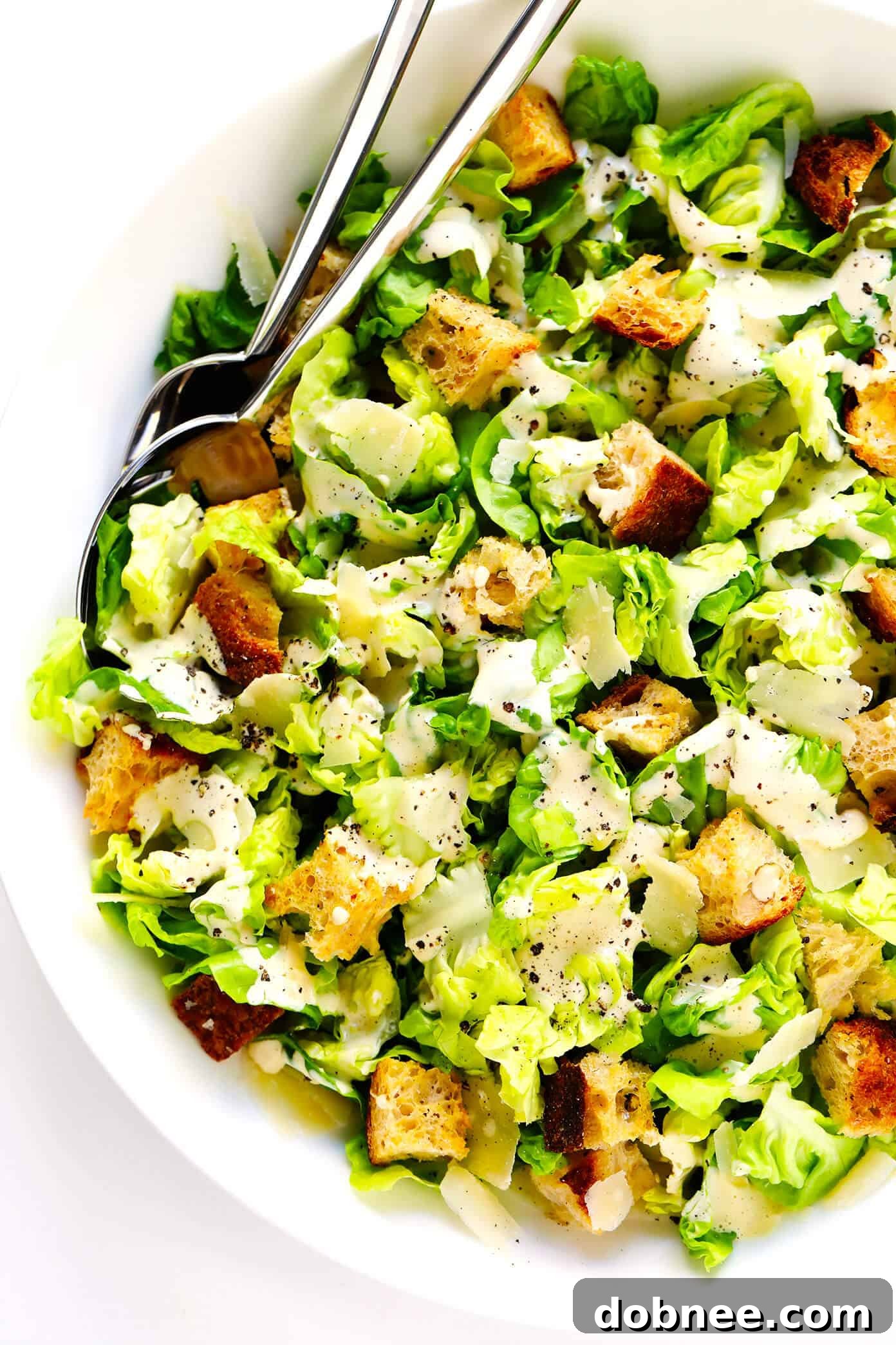 Homemade Caesar Salad with the creamy dressing freshly drizzled over crispy Romaine and croutons.